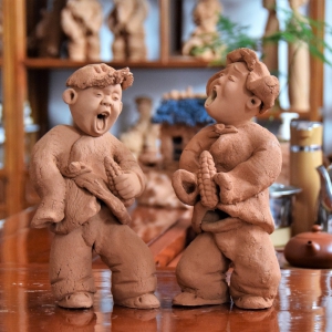 泥塑作品:抱玉米的娃娃
